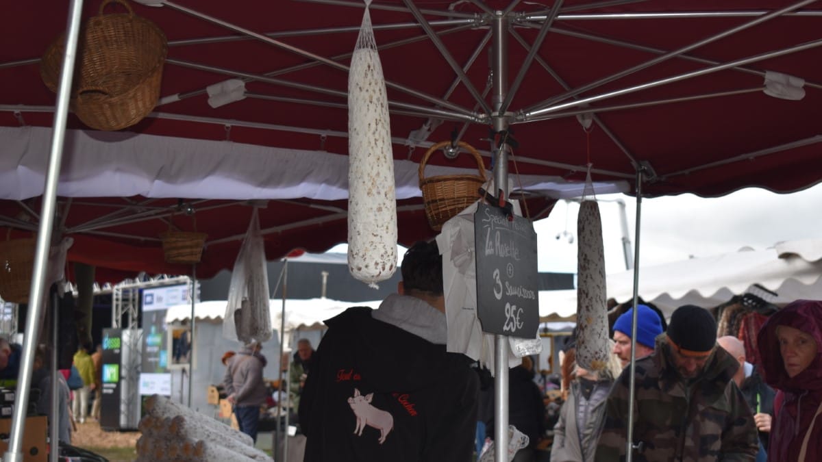 Charcuteries et rosettes suspendues sous un stand de foire